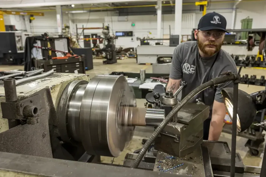 Man repairing cylinder with a machine